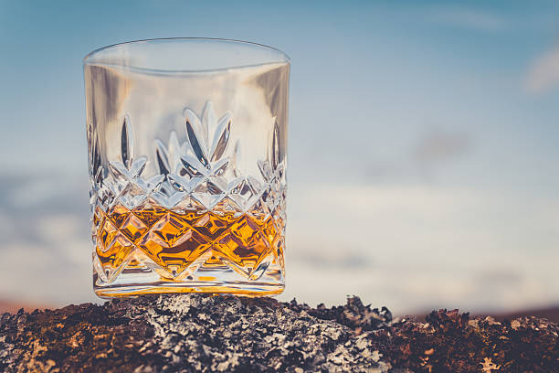 Glass of single malt Scotch Whisky on an old rock in the Highlands of Scotland.