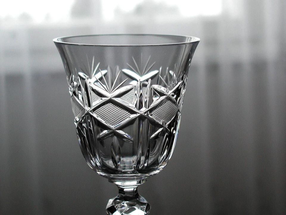Hand-cut crystal glass close-up showing sharp cut facets catching the light